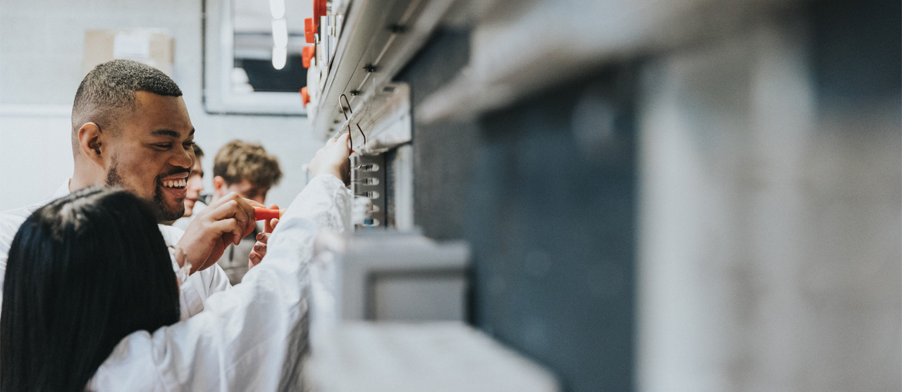 Twee studenten elektromechanica van HOGENT werken aan een technische elektriciteitskast.